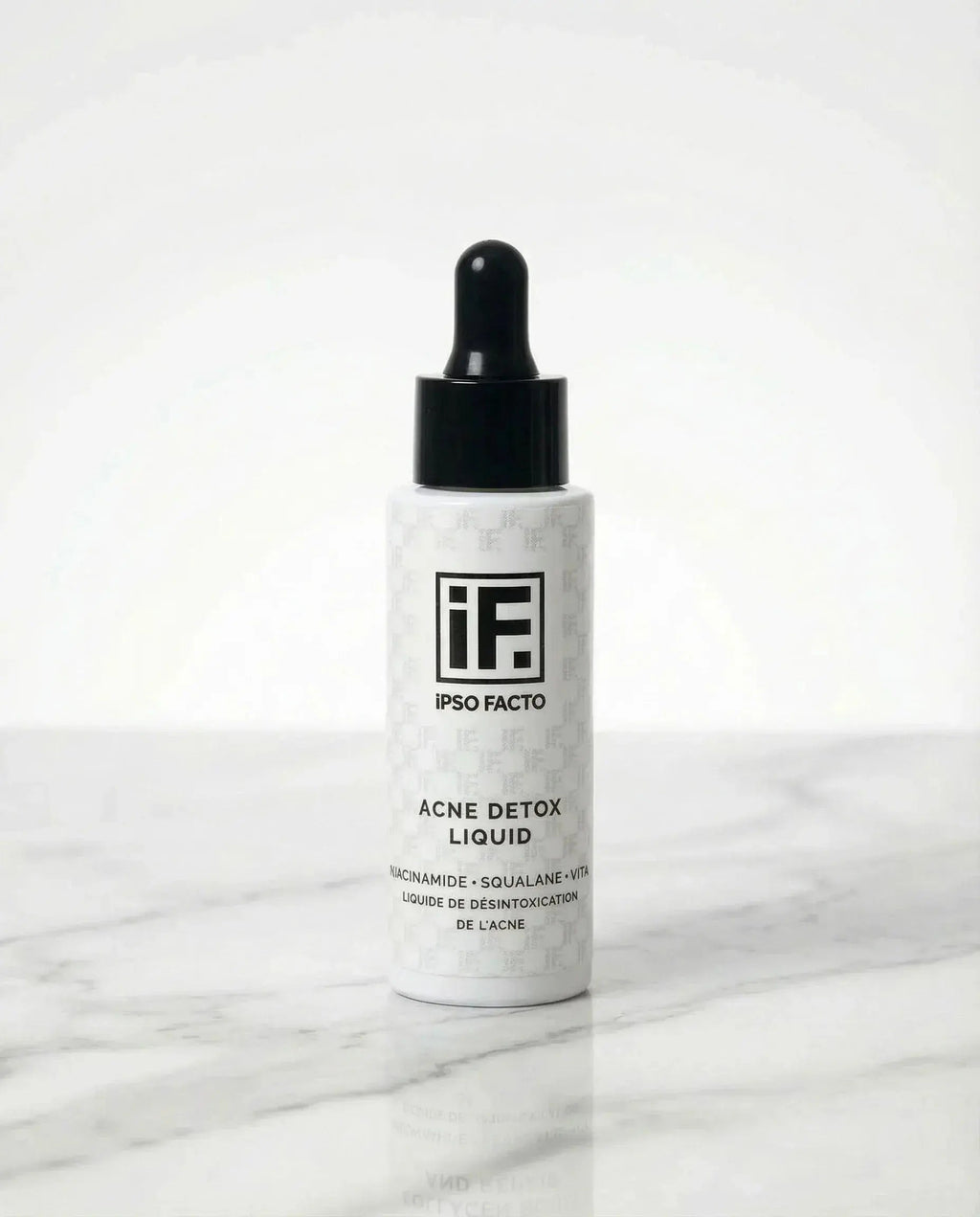 Acne Detox Liquid serum bottle with dropper on white marble background, skincare product