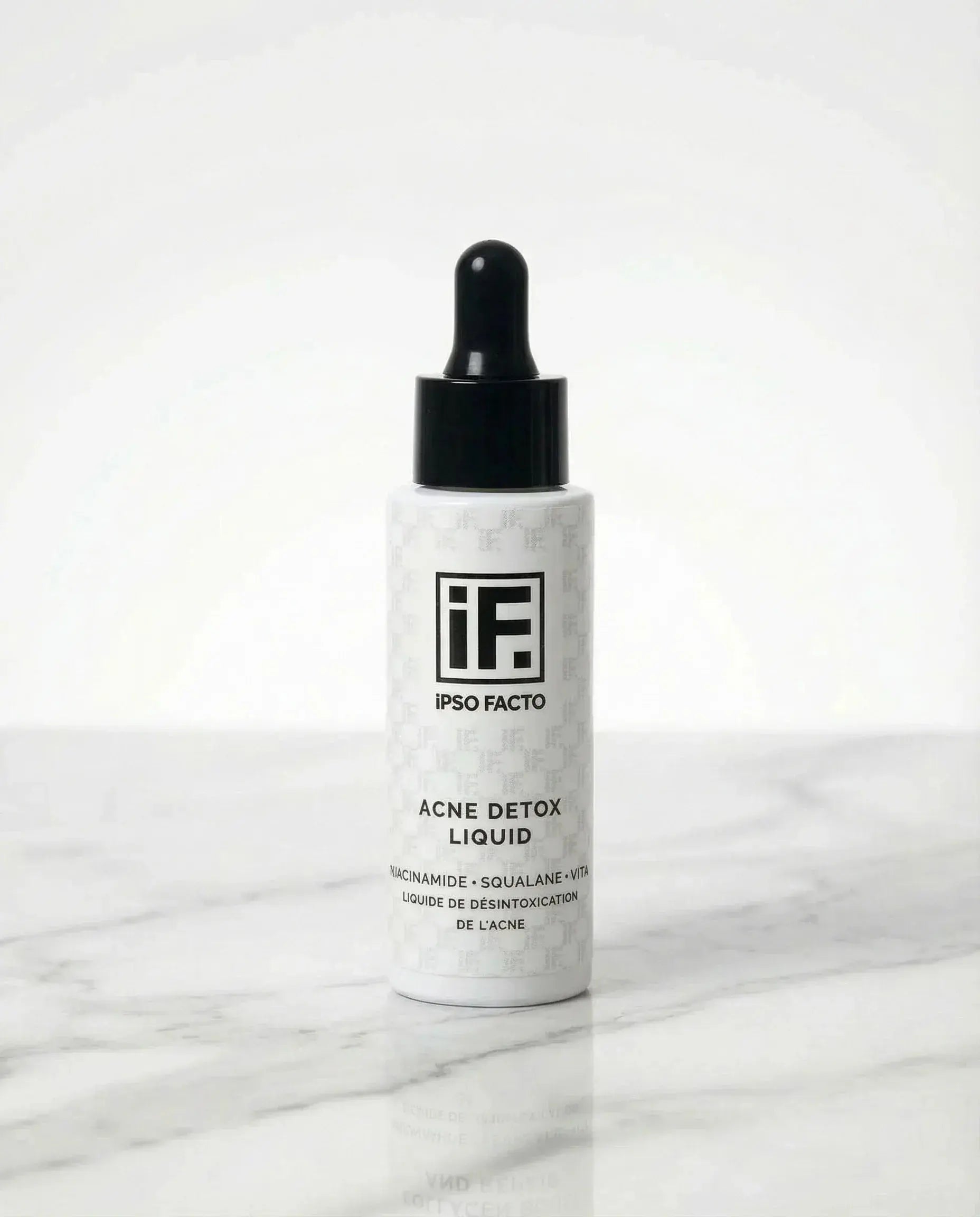 Acne Detox Liquid serum bottle with dropper on white marble background, skincare product