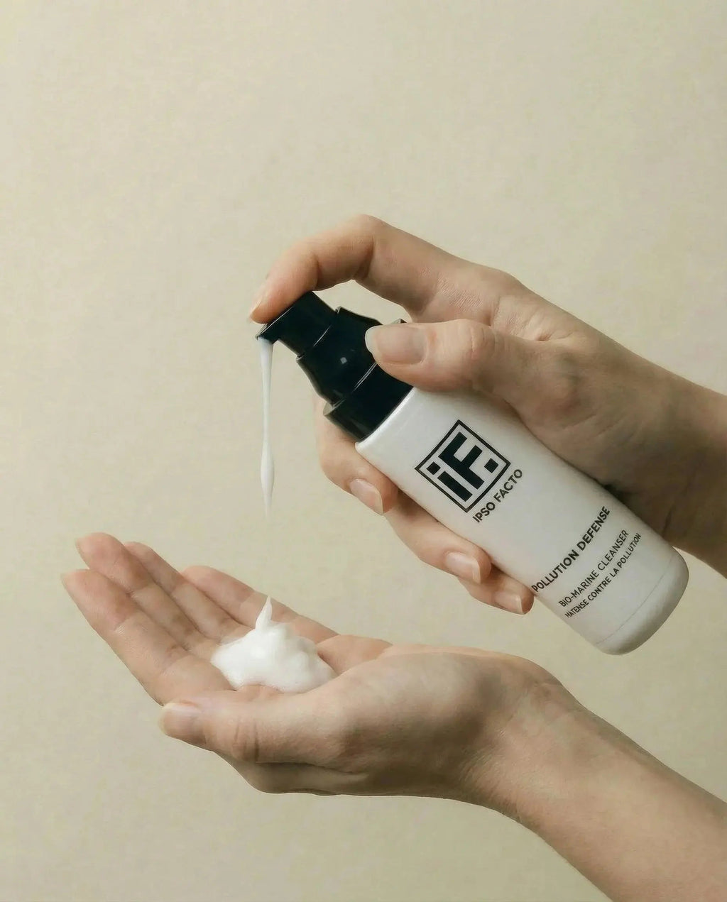 Hand dispensing Pollution Defence biomarine cleanser foam into palm, skincare product focus