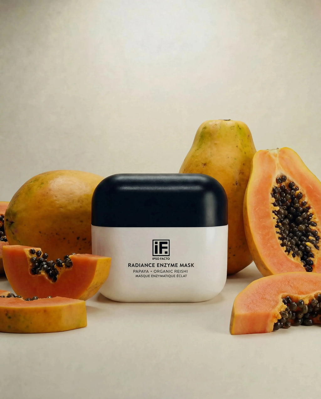 Radiance Enzyme Mask jar with papaya fruit slices on a neutral background, skincare product