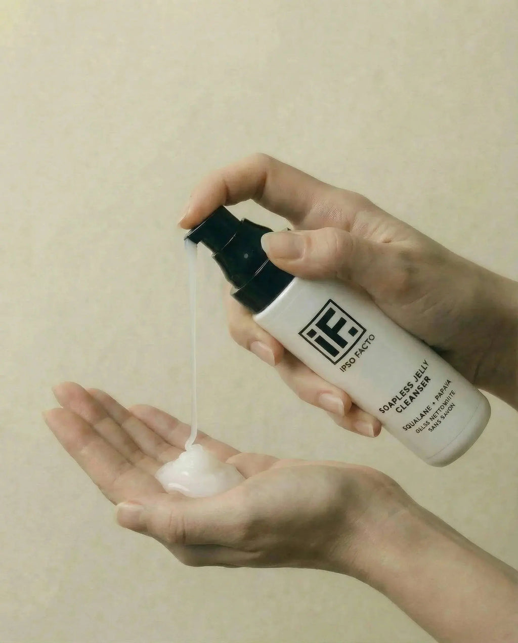 Dispensing soapless jelly cleanser into hand, gentle skincare product for sensitive skin